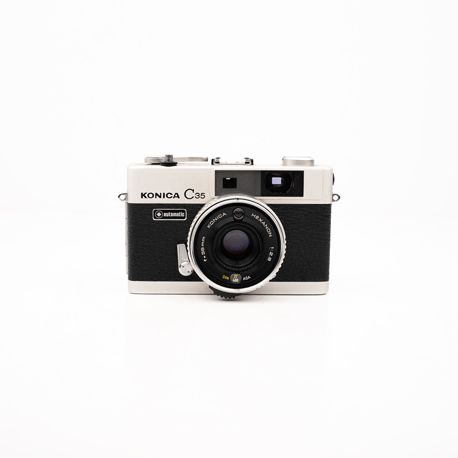 Câmara Range Finder Konica C35 — vista frontal, disponível na LX-FILM